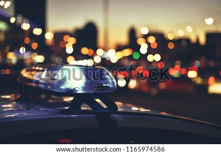 flashers of police car on background night city traffic