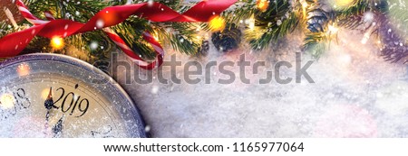 Countdown to midnight. Retro style clock counting last moments before Christmas or New Year 2019 next to decorated fir tree. View from above. Royalty-Free Stock Photo #1165977064