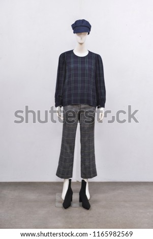 Full mannequin in female stripy clothes , stripy trousers,hat , black shoes isolated-gray background 