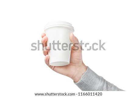 A paper cup of coffee in the hand. White paper cup of coffee in hand. For mock up/ Isolated