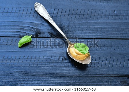 Honey mustard sauce and fresh basil on black wooden background