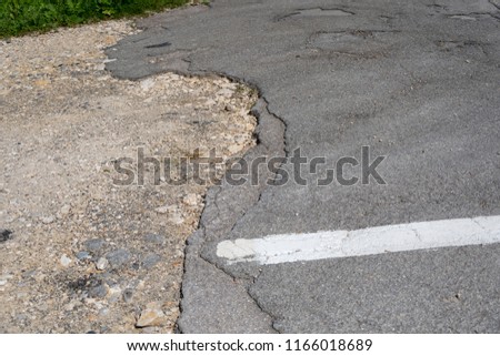 Broken asphalt street with white marks