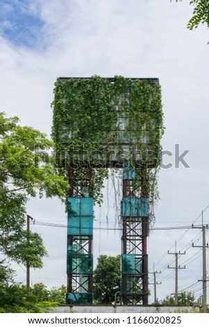 Old abandoned advertising billboard and covered with vines.The concept of business failure.