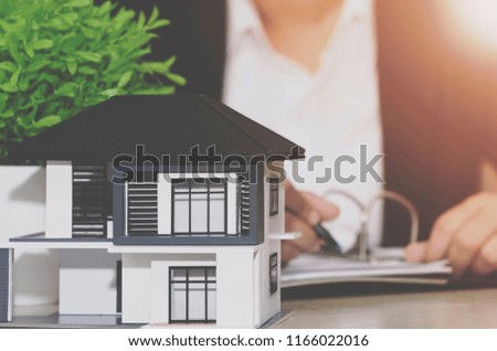 Real estate agent house represented by model;with background woman agent business.Real estate value concept.
