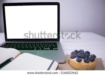 laptop showing blank screen on the whie table in coffee shop restaurant