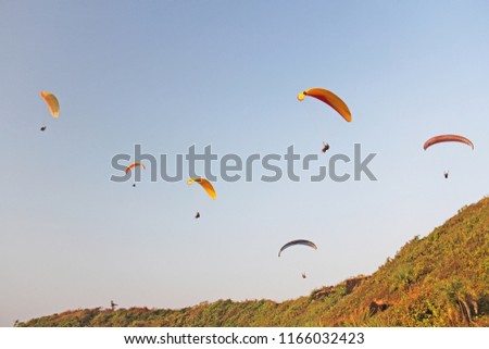 Paragliders against the blue sky. Bright paragliders fly in the sky. Extreme sport. Extreme. India, Goa.
