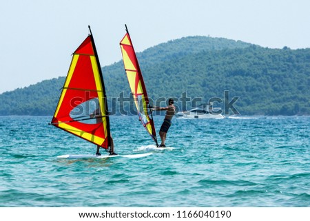 A picture of two windsurfs on the sea during the hot summer day. Pictured in Croatia. 