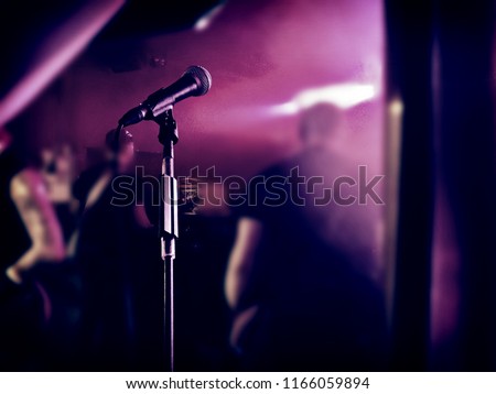 A classic microphone in front of a rock band. They played a concert in germany.