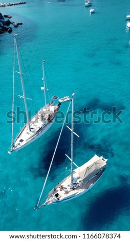 Aerial drone top view photo of luxury sail boats docked in tropical bay with turquoise and emerald clear sea