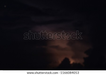 A lightning strikes within dark purple clouths