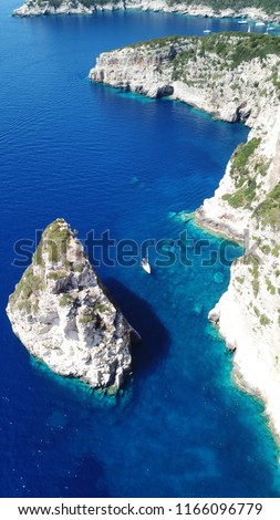 Aerial drone bird's eye view photo of tropical rocky bay of Ortholithos with famous cave of Papanikolis and turquoise calm waters forming a blue lagoon