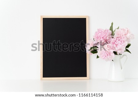 White portrait frame mock up with a pink peonies beside the frame, overlay your quote, promotion, headline, or design, great for small businesses, lifestyle bloggers and social media campaigns. poster