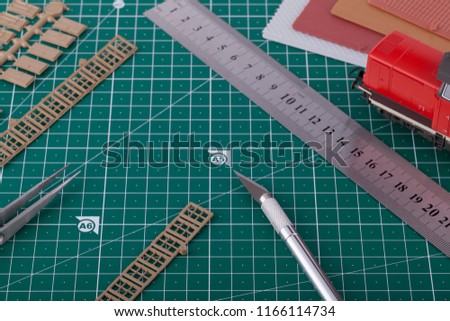 Creating train layout with tools on cutting mat