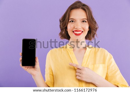 Image of cheerful woman isolated over purple wall background showing display of mobile phone.