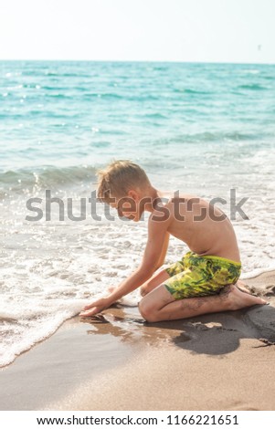 Cute blond hair boy playing at the beach