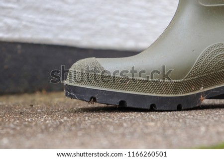 Green wellies on concrete