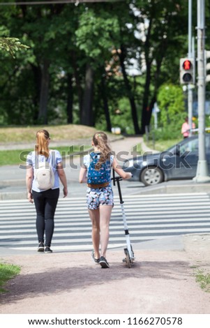 People standing at crosswalk, girl with kick scooter coming to road, red light