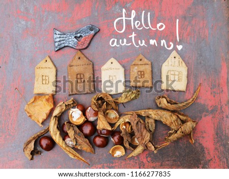 autumn background with autumn leaves ,chestnuts/figures of houses angels and birds/inscription "hello autumn"