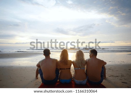 group of friends, youth sitting sunbathing on the beach / summer friends relaxing on the sea, vacation with friends on the coast tourism