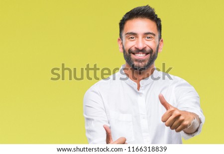 Adult hispanic man over isolated background approving doing positive gesture with hand, thumbs up smiling and happy for success. Looking at the camera, winner gesture.