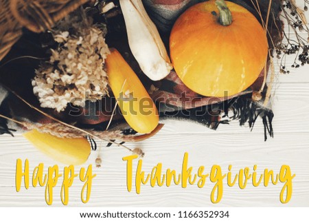 Happy Thanksgiving text, seasons greeting card. Thanksgiving sign. Pumpkin ,zucchini , wicker basket on white wooden background.  Fall Harvest