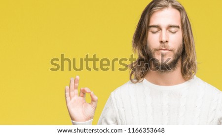 Young handsome man with long hair wearing winter sweater over isolated background relax and smiling with eyes closed doing meditation gesture with fingers. Yoga concept.