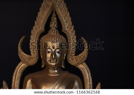 close up face of Buddha statue on black background