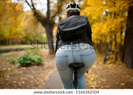 Photo from back of woman in helmet on bicycle