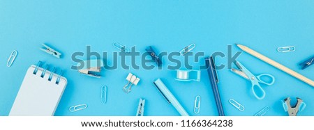 Top view flat lay of workspace desk styled design school and office supplies with copy space turquoise blue color paper background minimal style. Long wide banner Template feminine blog social media