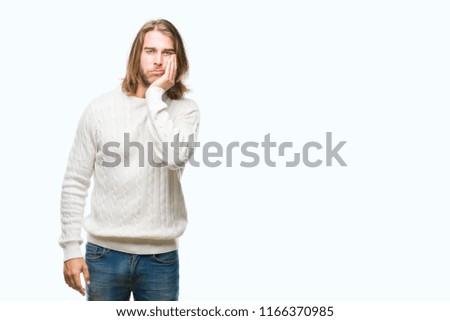 Young handsome man with long hair wearing winter sweater over isolated background thinking looking tired and bored with depression problems with crossed arms.