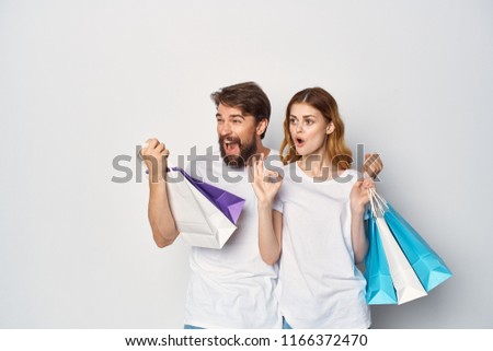 A man and a woman in white T-shirts are holding packing bags                           