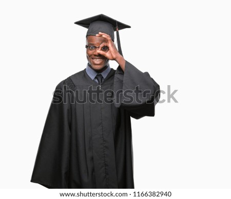 Young graduated african american man over isolated background doing ok gesture with hand smiling, eye looking through fingers with happy face.