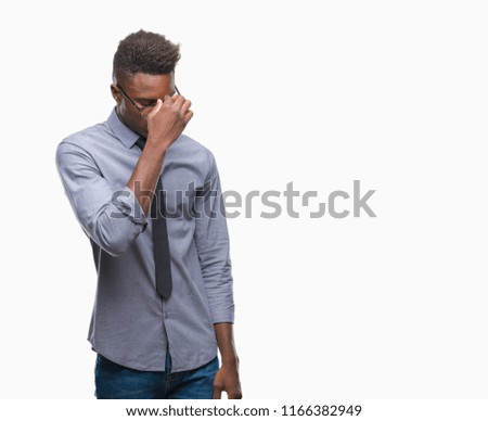 Young african american business man over isolated background tired rubbing nose and eyes feeling fatigue and headache. Stress and frustration concept.