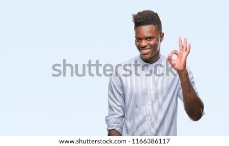 Young african american man over isolated background smiling positive doing ok sign with hand and fingers. Successful expression.