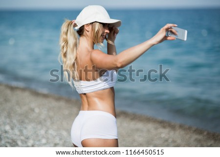  Sport athlete is taking selfie photos after working out running and training outdoors on the beach