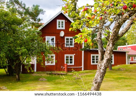 A typical red and white Scandinavian house for a family on the countryside in Sweden with a lot of garden around it Royalty-Free Stock Photo #1166494438