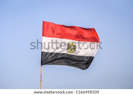 Egypt flag waving against clean blue sky. National flag of Egypt on a flagpole in front of blue sky.
