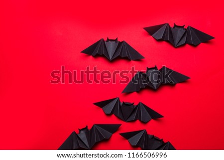 Halloween bats made from paper on a red background