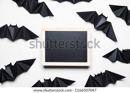 Halloween origami paper dracula bats with a blank blackboard