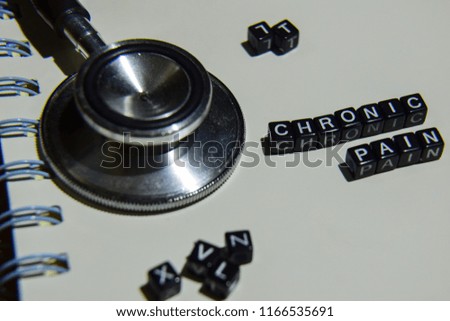 concept retro of Chronic Pain on wooden cubes with stethoscope, book