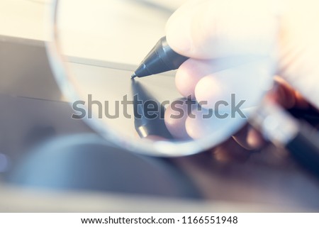 Concept of monitored, controlled, secret digital signature under a magnifying glass.