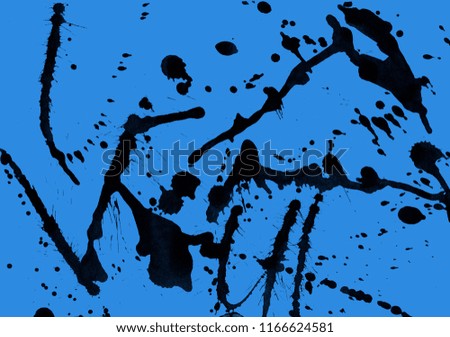 Isolated artistic black watercolor and ink paint splatter textures and decorative elements on blue paper background.
