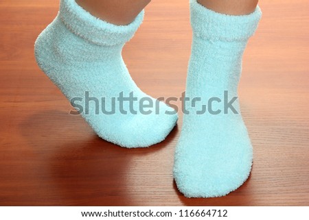 Legs female in blue socks on laminate floor