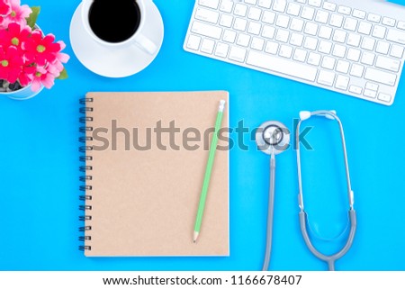 Top viwe of modern workplace with stethoscope and keyboard on blue table background. Flat lay design and copy space. Medical concept.