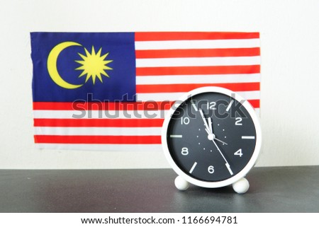 black and white clock with Malaysia flag as a background and with different timing. 

