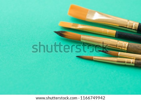 Bunch of Various Kinds of Paint Brushes on Light Green Background. Copy Space for Artwork Lettering Calligraphy Text Inspirational Quote. Creativity Arts Business Product Branding Promotion