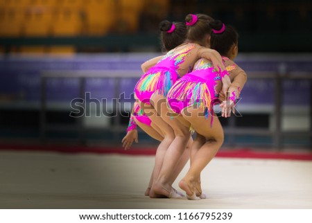 Girls in beautiful gymnastic dresses doing exercise