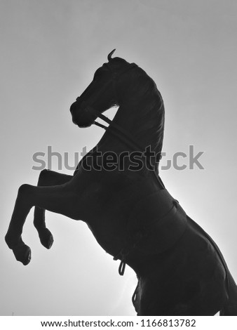 A black and white picture of a horse replica.