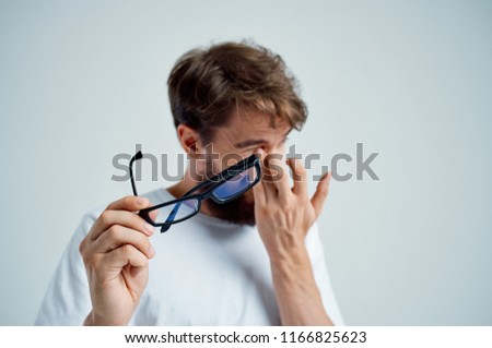 man wipes his face and glasses in his hands                   