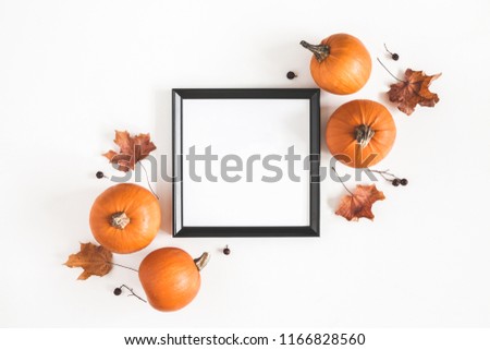 Autumn composition. Photo frame, pumpkins, dried leaves on white background. Autumn, fall, halloween concept. Flat lay, top view, copy space, square